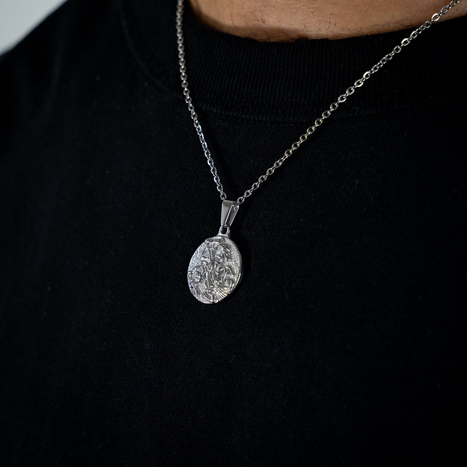 Silver necklace with a pendant on a black background