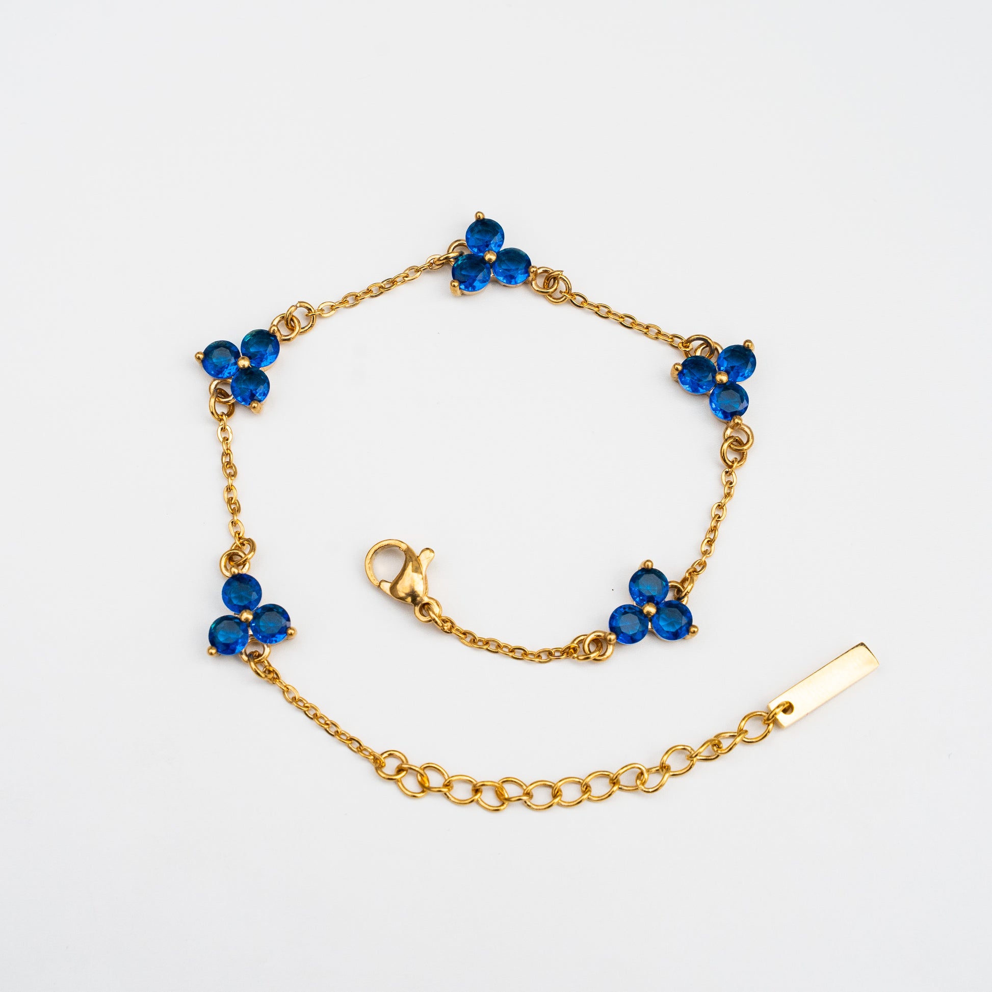 Gold bracelet with blue gemstones on a background