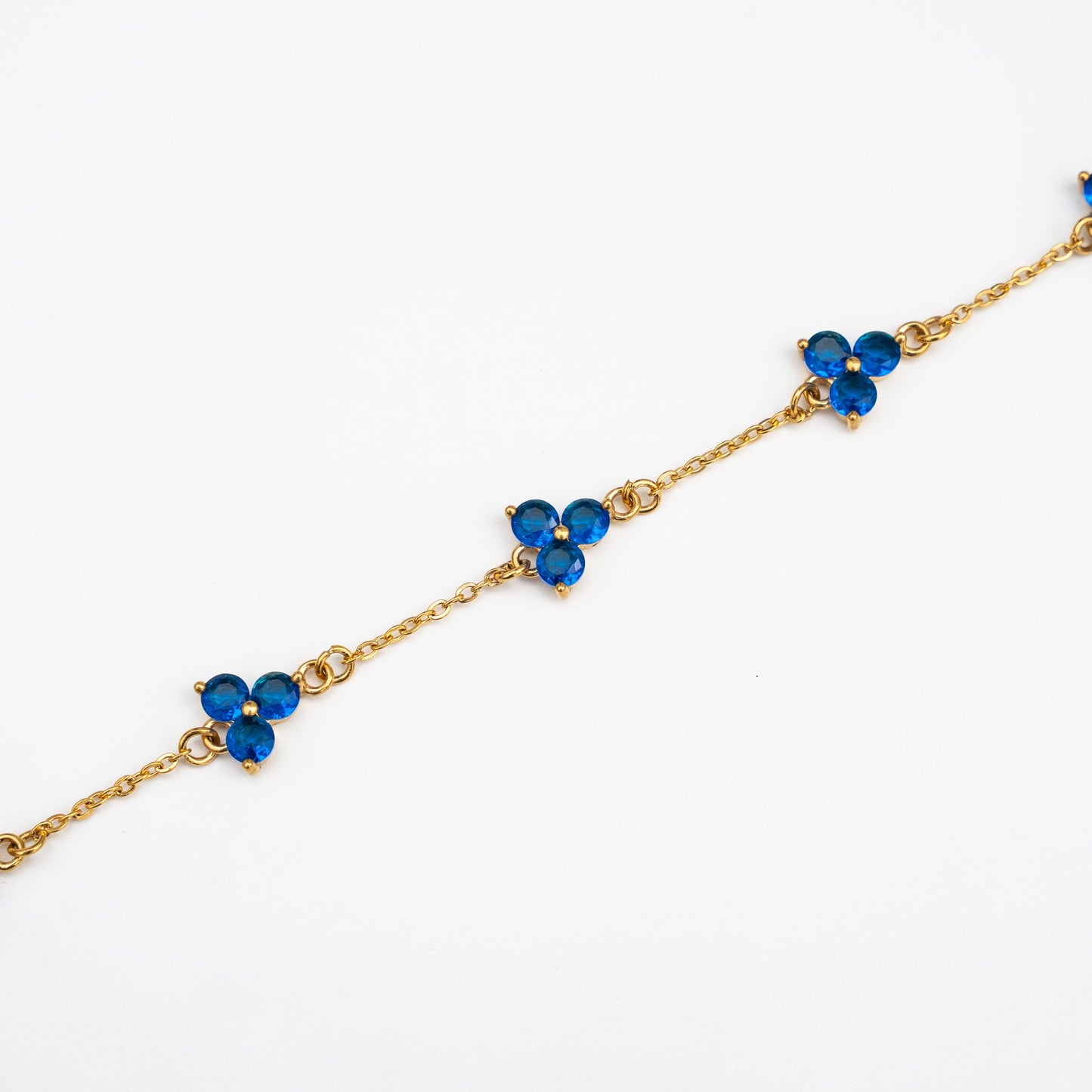 Gold bracelet with blue gemstones on a background