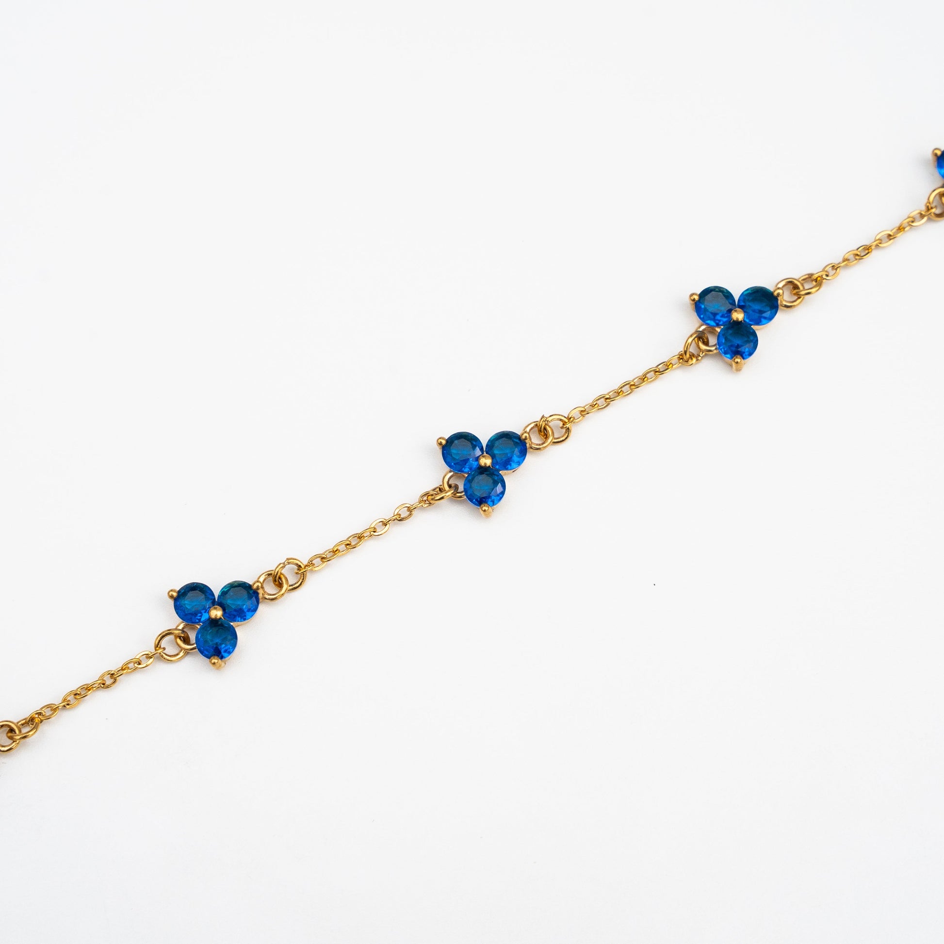 Gold bracelet with blue gemstones on a background