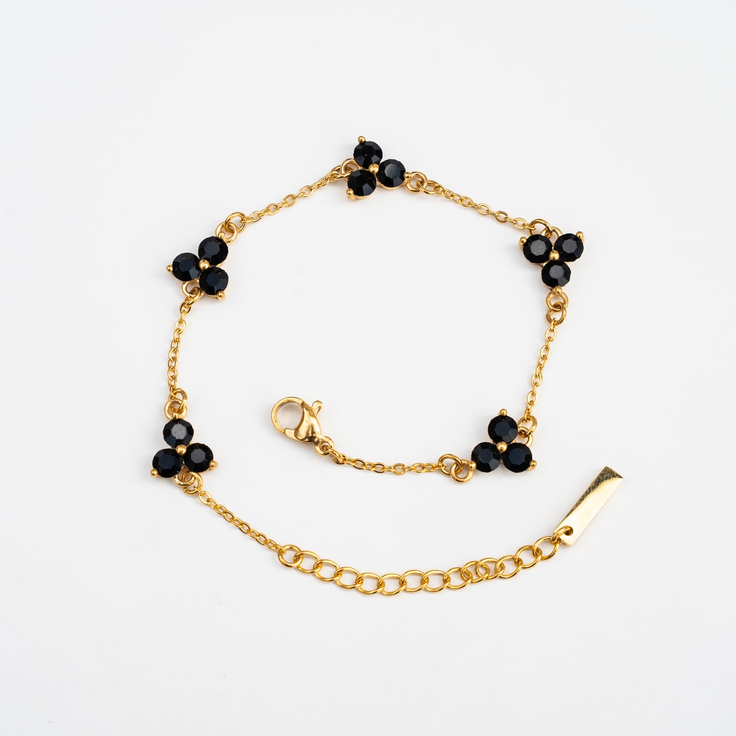Gold bracelet with black gemstones on a background