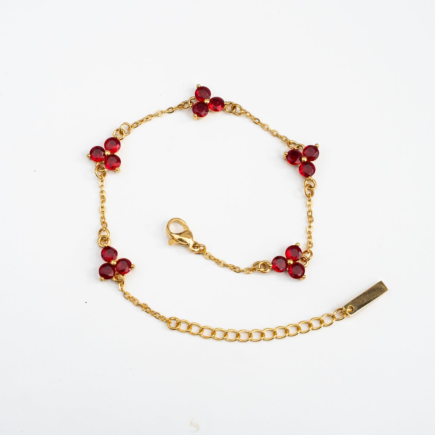 Gold bracelet with red gemstones on a background