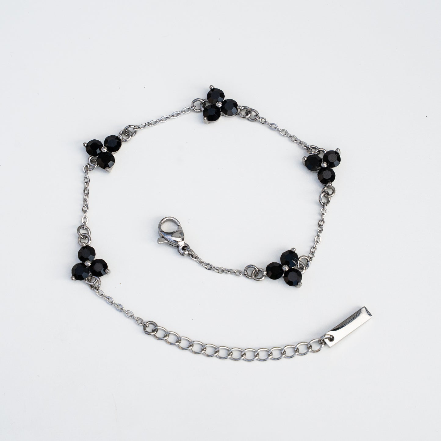 Silver bracelet with black gemstones on a background