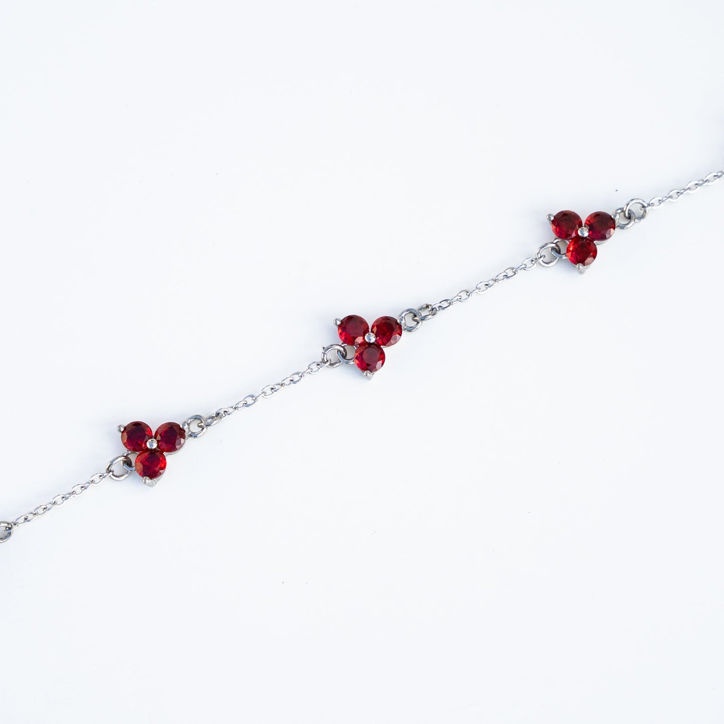 Silver bracelet with red gemstones on a background