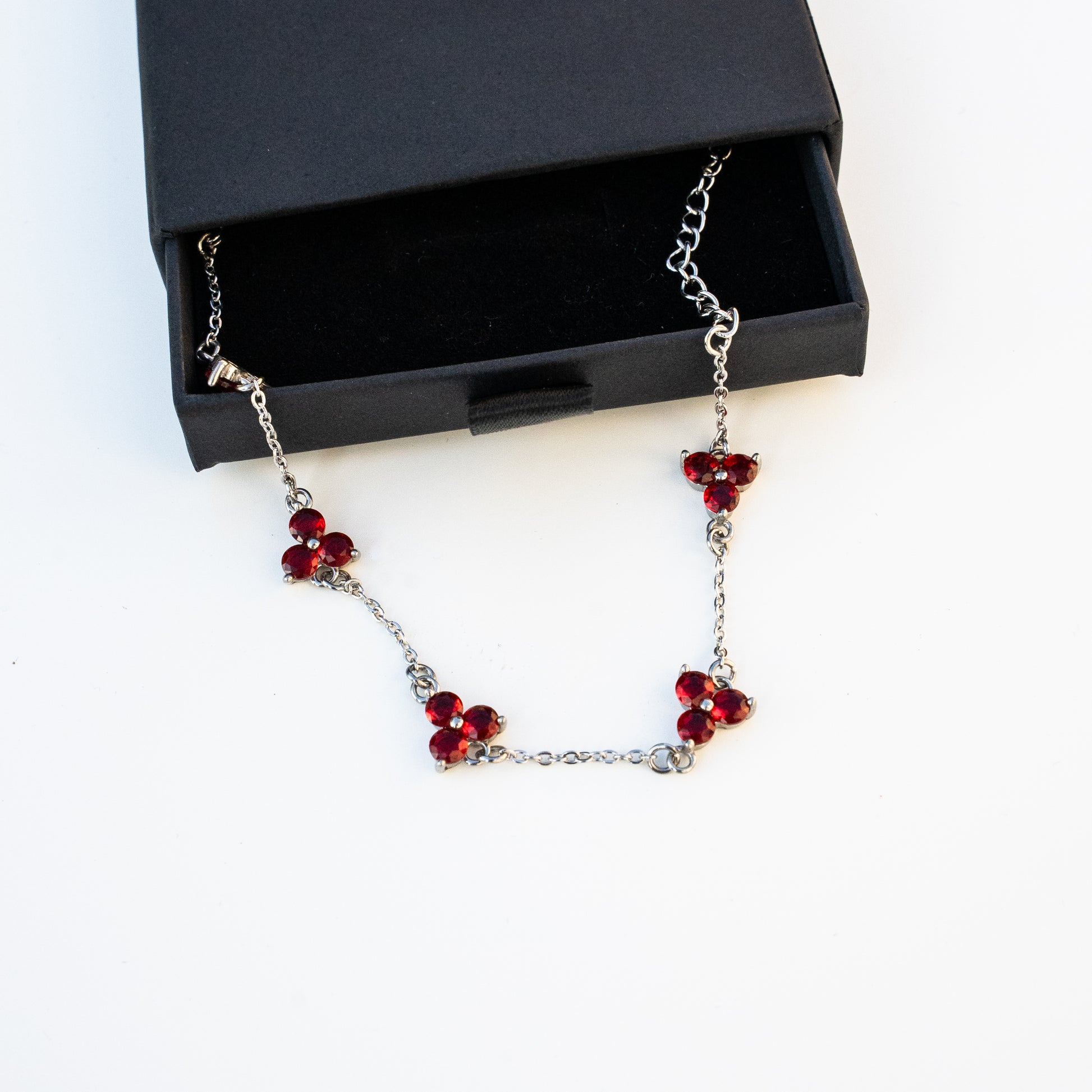 silver Necklace with red beads on a background